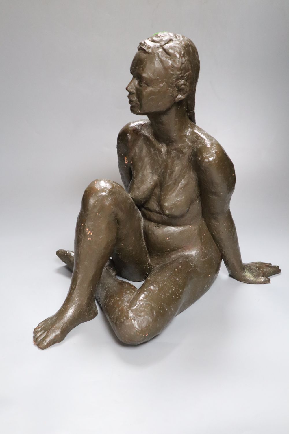 M. Pike. A bronzed terracotta figure of a seated nude female, height 38cm